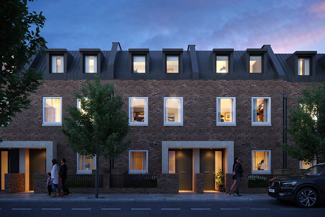 A row of modern brick terraced houses with large windows illuminated at dusk, trees along the pavement, and people walking and standing near the entrances.